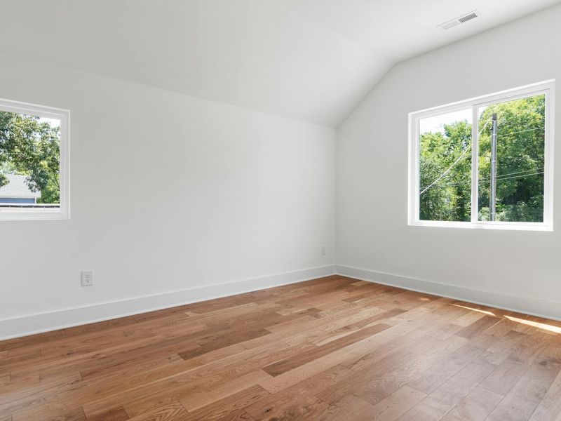 Bright and airy home gym with wooden floors and large window
