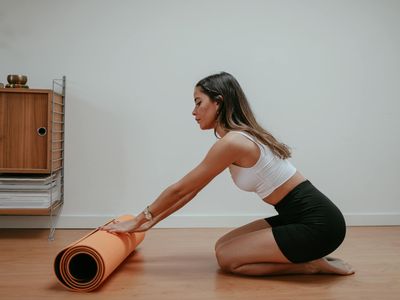 Clean yoga mat rolled up on a white floor