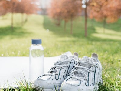 Close up of a pair of running shoes and a water bottle