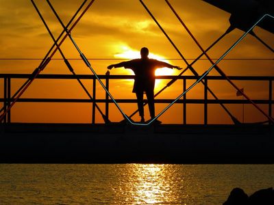 Silhouette of a person stretching against a sunset sky